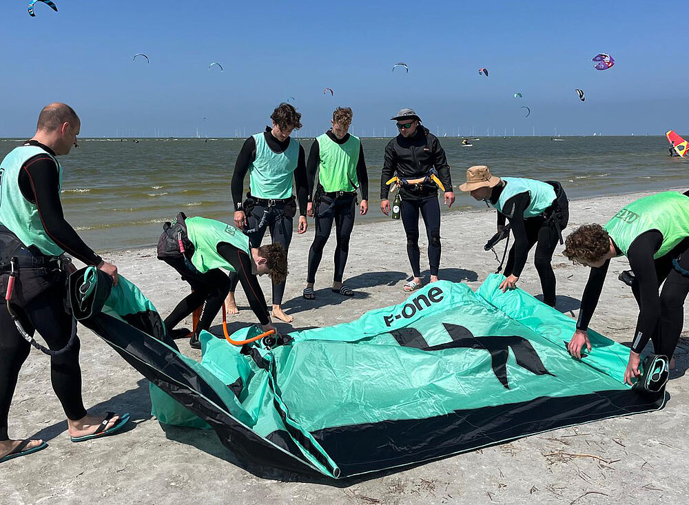Kitesurf Holland005 und Gruppe beim Kitesurfing-Kurs am Strand, Kite-Setup und Wassersport-Training in Holland