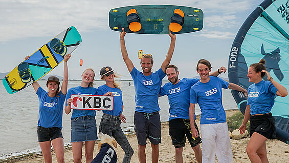 Équipe de kitesurf KBC Sizilien célèbre sur la plage avec planches de kite et Sizilien - sports nautiques