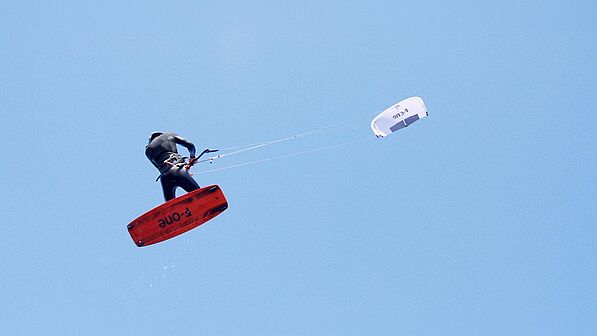 Kitesurfer F-ONE kiteboarding with Bandit Kite in the air, spectacular jump during water sports in the KBC World network