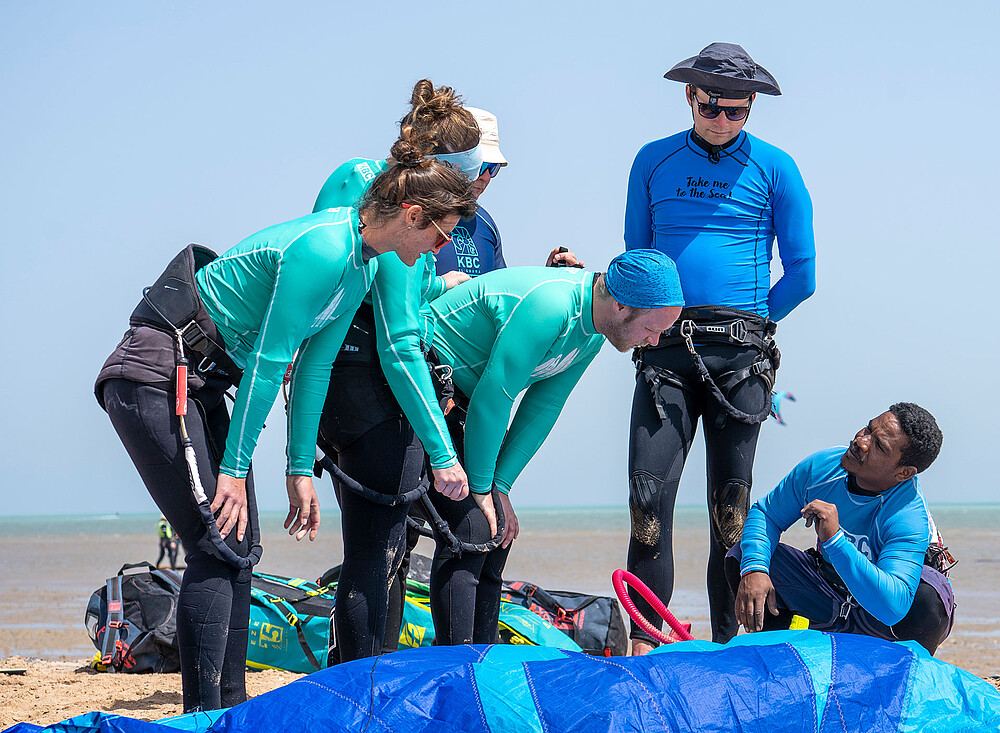 Kitesurfing Event EG: instructeurs helpen leerlingen met kitesurfles op strand met kite-uitrusting en materiaal