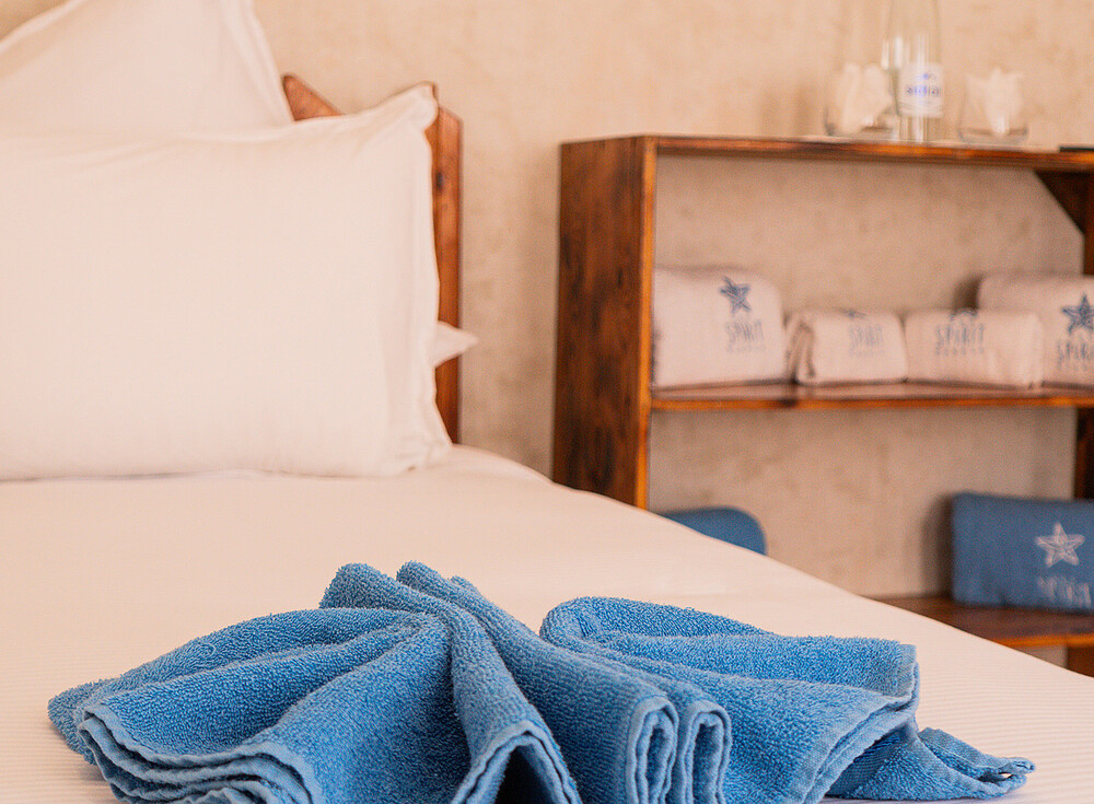 NewSpiritDakhla Bungalow Standard bedroom with blue towels, kiteboarding accommodation Dakhla Morocco travel