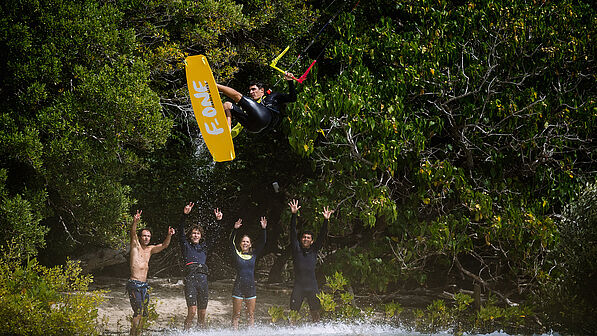 Kitesurfer im Sprung High-Five - Kiteboarding Tricks und Wassersport Spaß