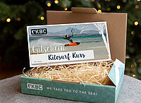 CKBC kitesurfing cursus voucher cadeaubox met stro, kitesurfer op strand, watersport cadeau