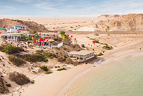 Kitesurfing strand met kleurrijke kites en kiteboard centrum aan woestijnkust, News Spirit kitesurfing bestemming