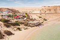 Kitesurfing strand met kleurrijke kites en kiteboard centrum aan woestijnkust, News Spirit kitesurfing bestemming