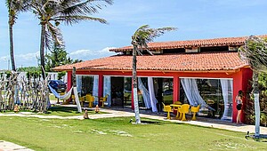 Kiteboarding Club KBC Parajuru red building with palm trees and garden in Ceará, Brazil - perfect kitesurfing holiday