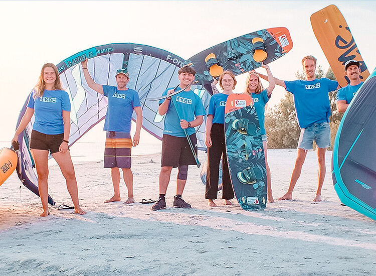 Kitesurfing groep met kites en boards op strand - watersport avontuur en kiteboard reisbestemming