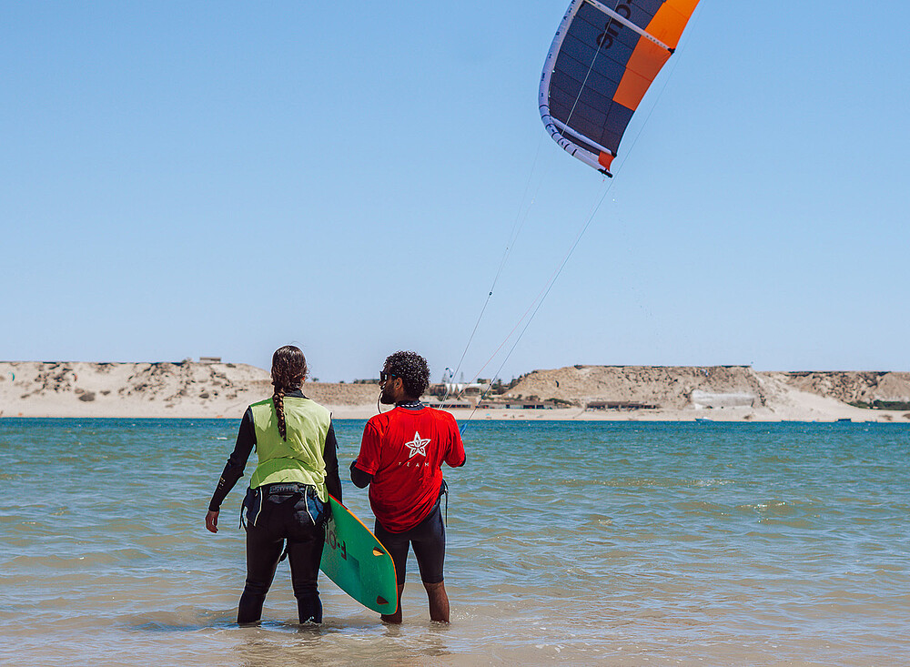NewSpiritDakhla Kitesurf instructor at Dakhla beach - kiteboarding lesson with kite against blue sky