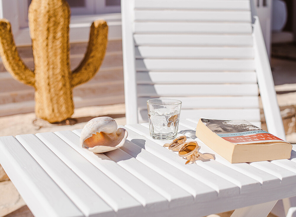 NewSpiritDakhla Premium Bungalow terrace with cactus decor, book and sunglasses - kiteboarding accommodation Dakhla