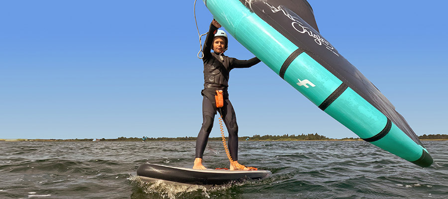 Wingfoil Kids beim KBC Brouwersdam Holland - Kind auf Wingfoil Board mit Wing Segel auf dem Wasser bei blauem Himmel