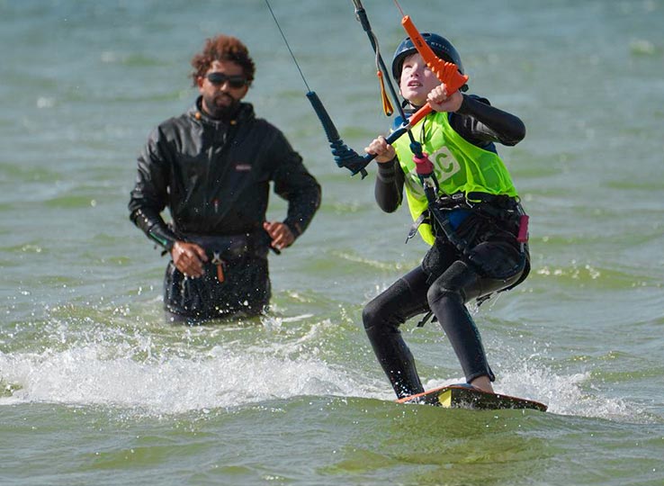 Kitesurflessen voor kinderen bij de KBC Dakhla kiteschool Vliegerlessen voor kinderen met instructeur in het water tijdens he