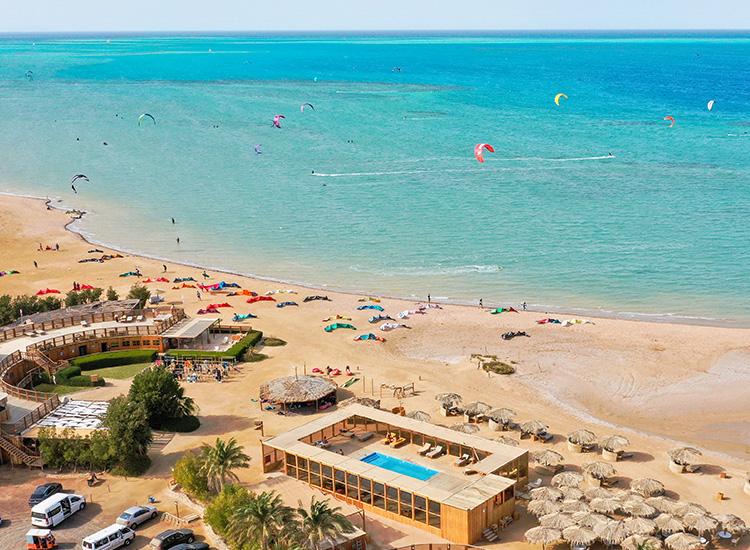 Luchtfoto Kiteboarding Club KBC El Gouna met turquoise zee, zandstrand en kleurrijke kites - Centerprofil