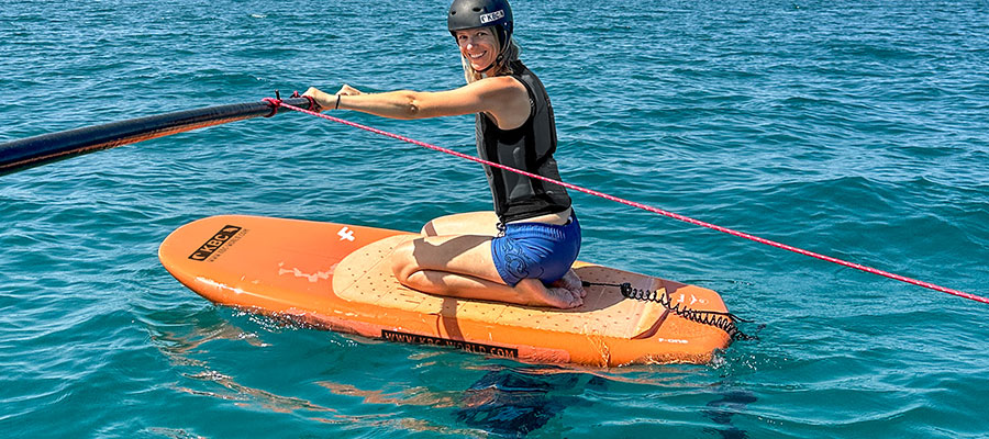 Foilsimulator beim Kiteboarding Training auf orangem Board im türkisblauen Wasser - Wassersport und Kitesurfen lernen