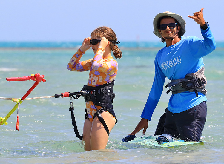 Cursus kitesurfen voor kinderen in turquoise wateren bij KBC El Gouna Kiteschool - kite-instructeur en leerling met kiten van