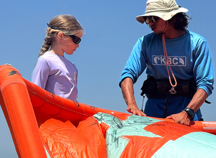 Kitekursus kitesurfen voor kinderen: leerling en instructeur kiten op het strand - watersporten leren voor kinderen bij KBC E