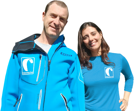 Franky en Anabel lachend in blauwe kitesurfing kleding op strand - kiteboarding instructeurs voor watersport