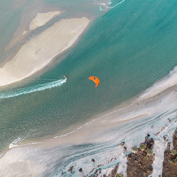 Vista aérea BR Consorti praticando kitesurf nas águas cristalinas da praia KBC Parajuru Ceará Brasil esportes aquáticos