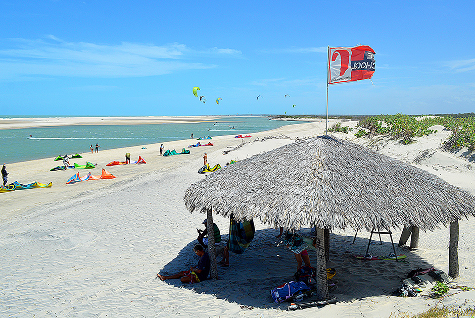 Kiteboarding beach at KBC Kitesurf Center Parajuru with palm hut, colorful kites and water sports in Ceará Brazil