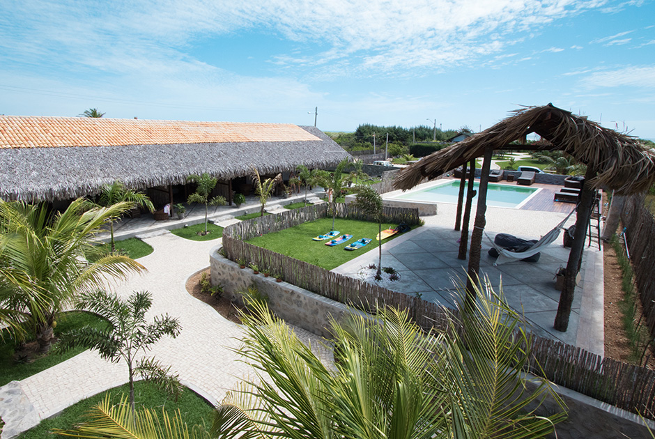 Kiteboarding Club KBC Parajuru resort with swimming pool, palm trees and thatched roof buildings in Ceará Brazil