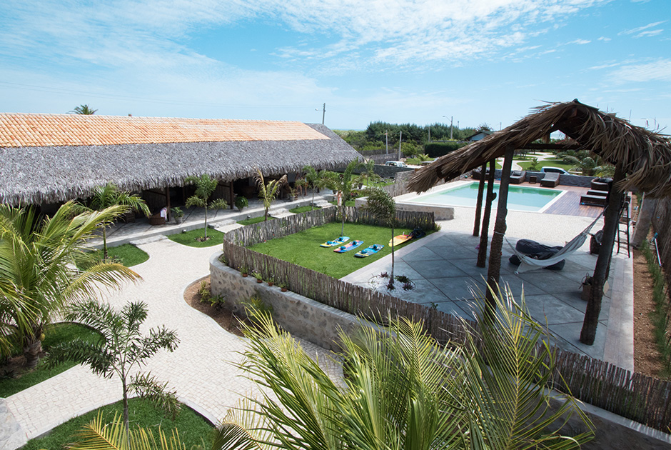 Kiteboarding Club KBC Parajuru resort with swimming pool, palm trees and thatched roof buildings in Brazil