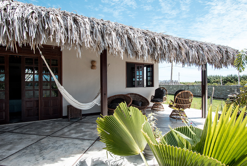 Tropical palm-thatched accommodation at Kiteboarding Club KBC Parajuru with hammock and outdoor lounge area