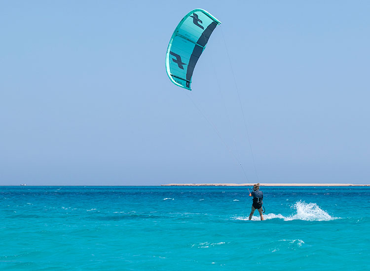 Ras praticando kitesurf em águas turquesa no KBC Kitesurf Center Ras Soma, Mar Vermelho Egito