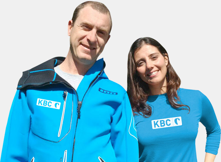 Franky en Anabel van KBC Kitesurf Center Tarifa in blauwe kitesurfkleding bij advies over kiteboarding lessen