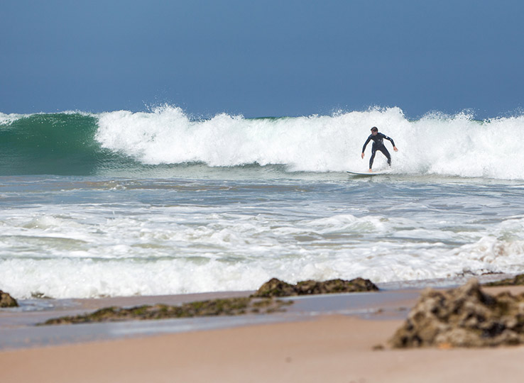 Kitesurfer Wavespot op golven bij zandstrand - watersport reisbestemming voor kitesurfen