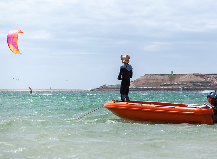 Rescue Boat kitesurfing veiligheid - watersport instructeur bewaakt kiteboarding sessie vanaf oranje reddingsboot