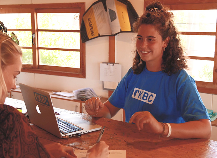 Profil en Rezeption aan laptop in kitesurfstation - advies voor kiteboard lessen en reisbestemmingen