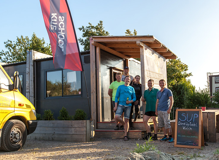 Kitesurfing crew bij mobiele kitesurf winkel met foodtruck op strand - perfecte stop voor kite gear en versnaperingen