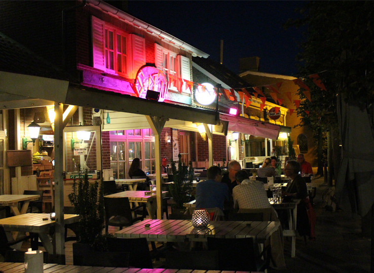 Levendige strandrestaurant 's avonds met buitenterras - perfecte plek om te ontspannen na het kitesurfen