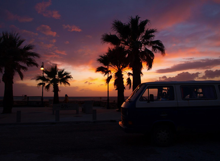 Tropisch strand zonsondergang met palmbomen en busje - ideale kitesurfing en kiteboarding reisbestemming voor watersport