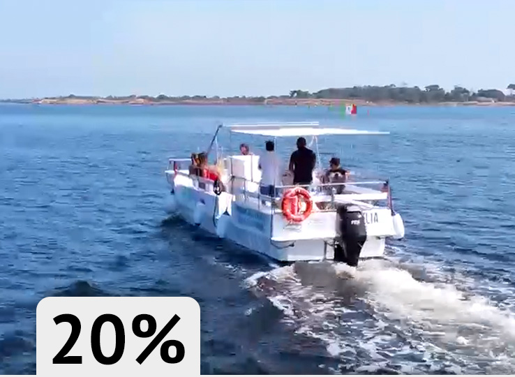 Witte vissersboot op blauw water bij kustlijn - perfecte omstandigheden voor kitesurfen en watersporten