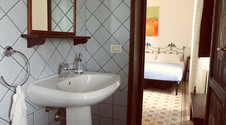 Bathroom in kiteboarding accommodation with white sink and bedroom view - comfortable travel lodging for kitesurfers
